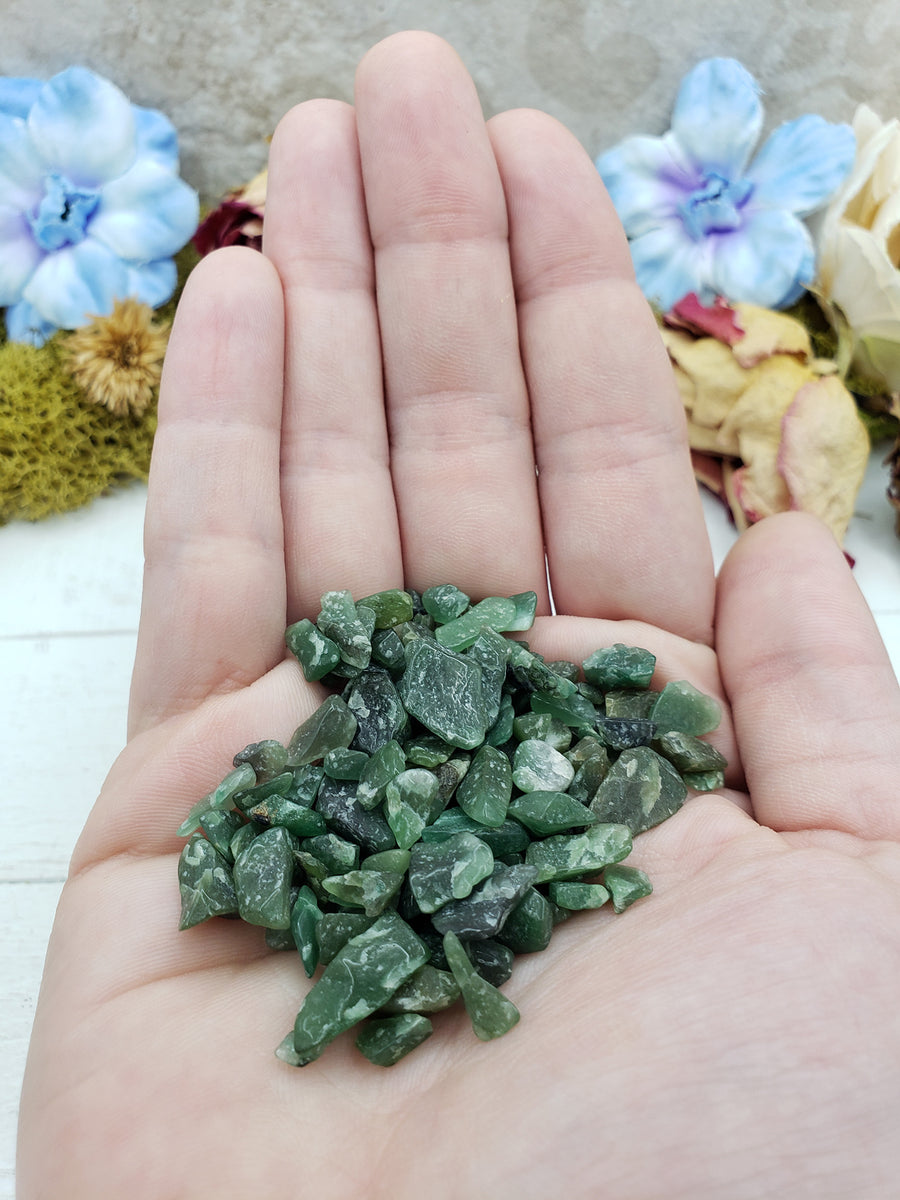Hand holding one ounce of green aventurine chips