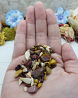 Hand holding one ounce of mookaite crystal chips