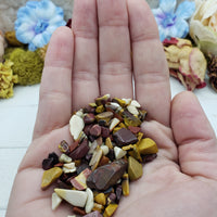 Hand holding one ounce of mookaite crystal chips