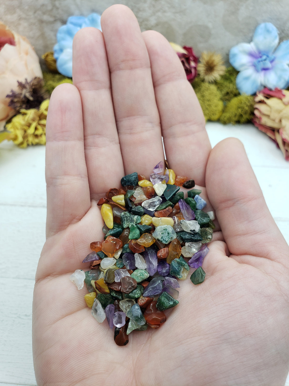 Hand holding one ounce of mixed gemstone crystal chips
