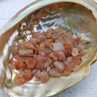 one ounce of sunstone crystal chips in abalone shell