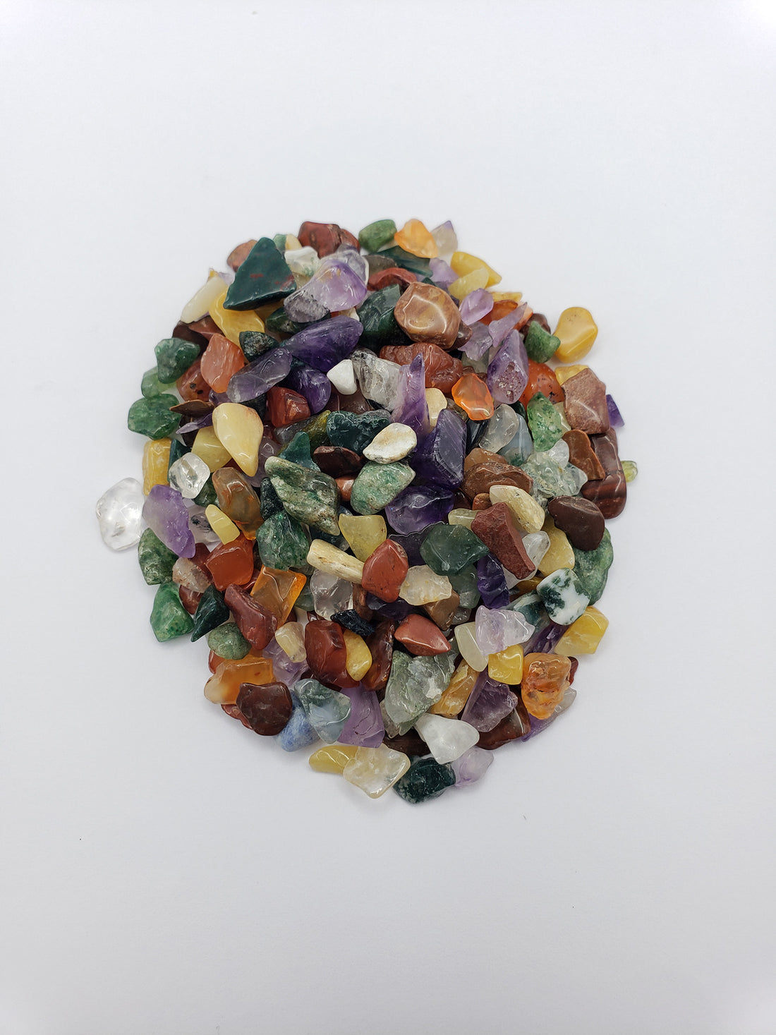 One ounce of mixed gemstone crystal chips on white backgroun