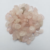 one ounce of rose quartz crystal chips on white background