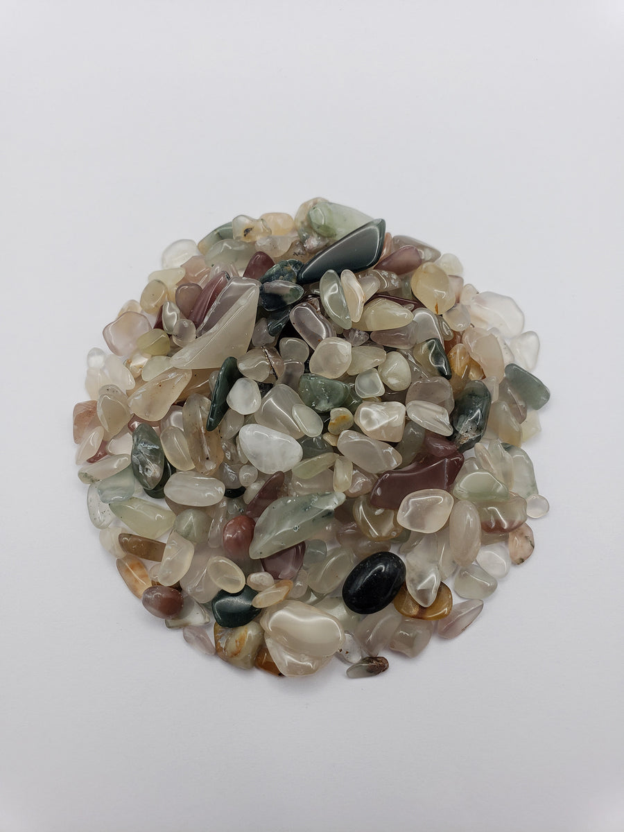 One ounce of mixed agate crystal chips on white background