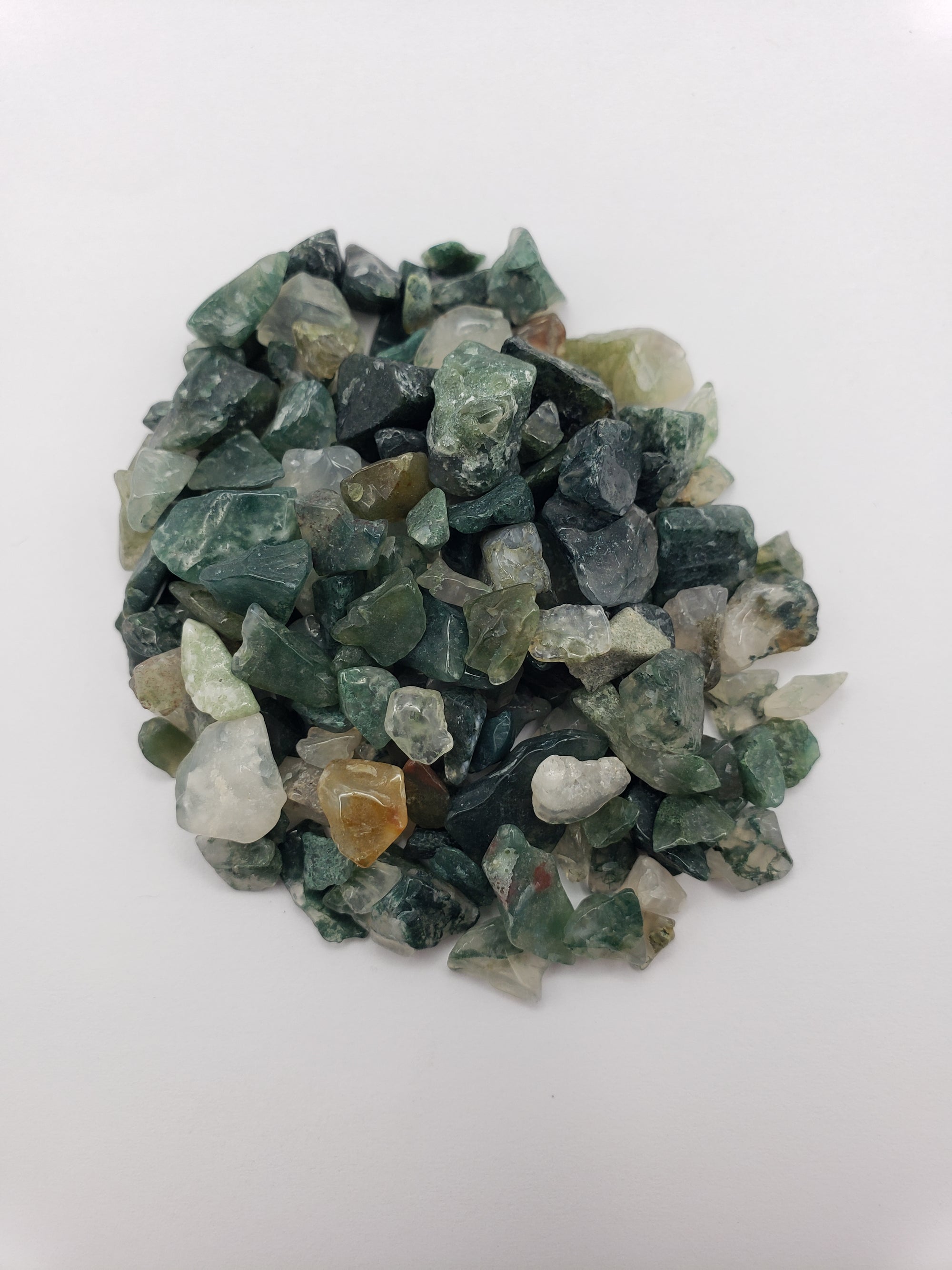 One ounce of moss agate chips on white background