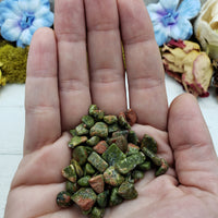 hand holding 1 ounce of unakite chips