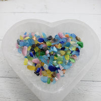 1 ounce of rainbow cats eye stone chips in selenite bowl
