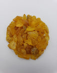 24 grams of amber crystal chips on white background