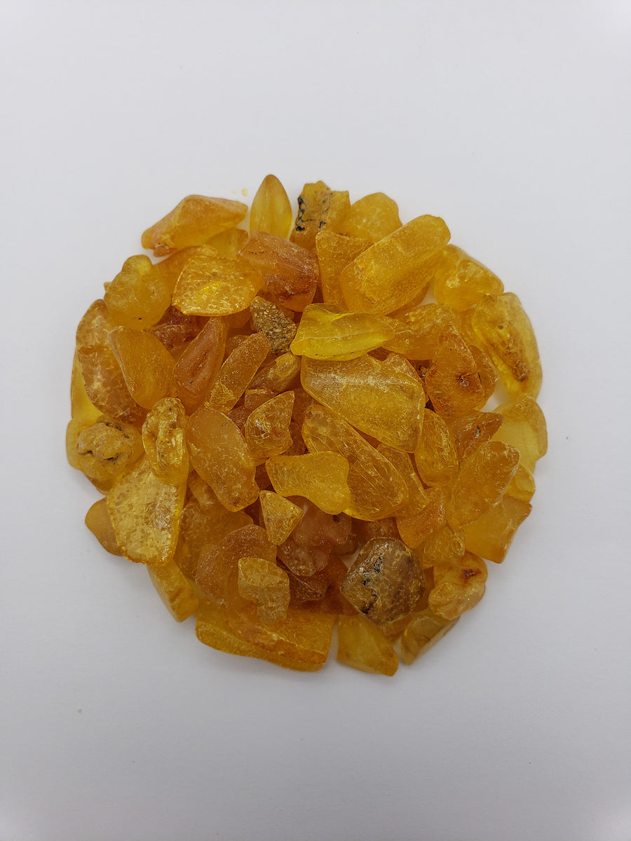 24 grams of amber crystal chips on white background