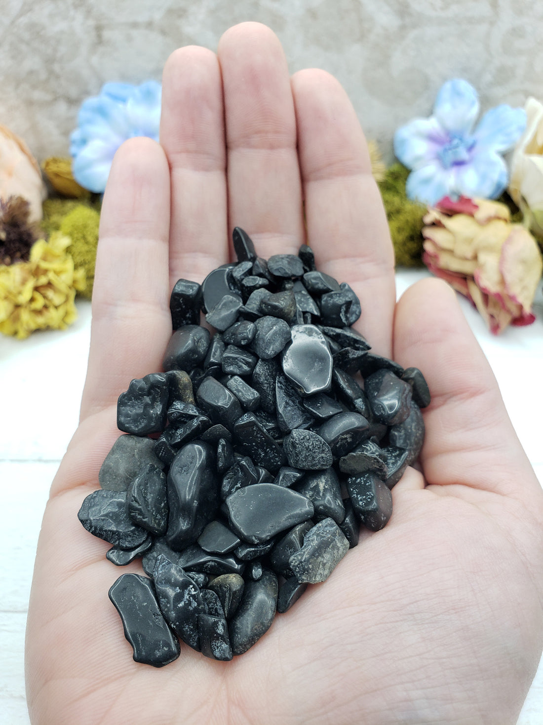hand holding 3 ounces of black tourmaline chips