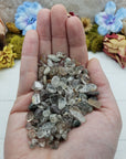 Three ounces of hand holding green phantom quartz chips