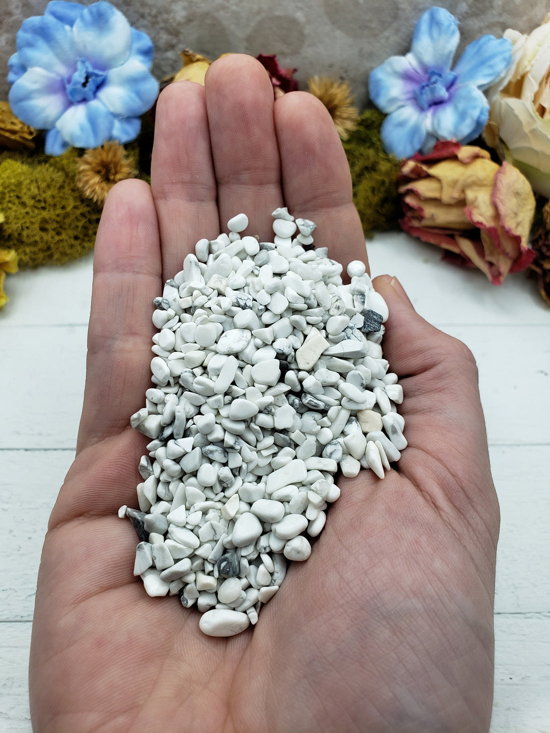 Hand holding three ounces of howlite chips