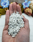 Hand holding three ounces of howlite chips