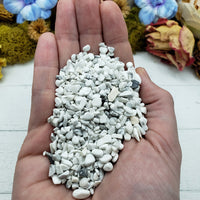 Hand holding three ounces of howlite chips