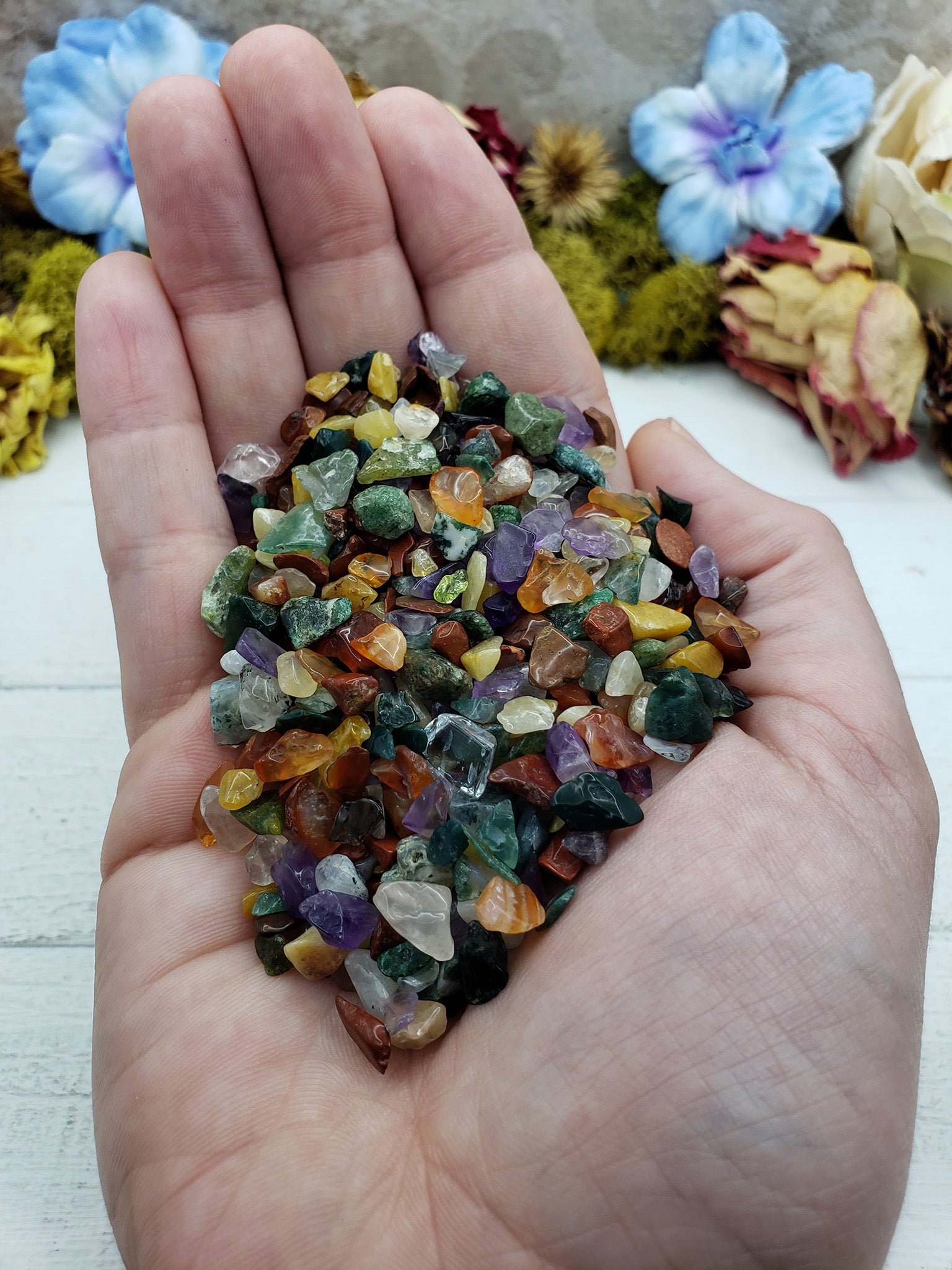 Hand holding three ounces of mixed gemstone crystal chips