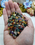 Hand holding three ounces of mixed gemstone crystal chips