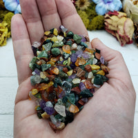 Hand holding three ounces of mixed gemstone crystal chips