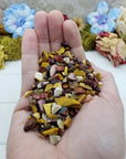 Hand holding thee ounces of mookaite jasper chips