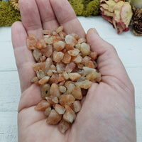 hand holding three ounces of sunstone crystal chips