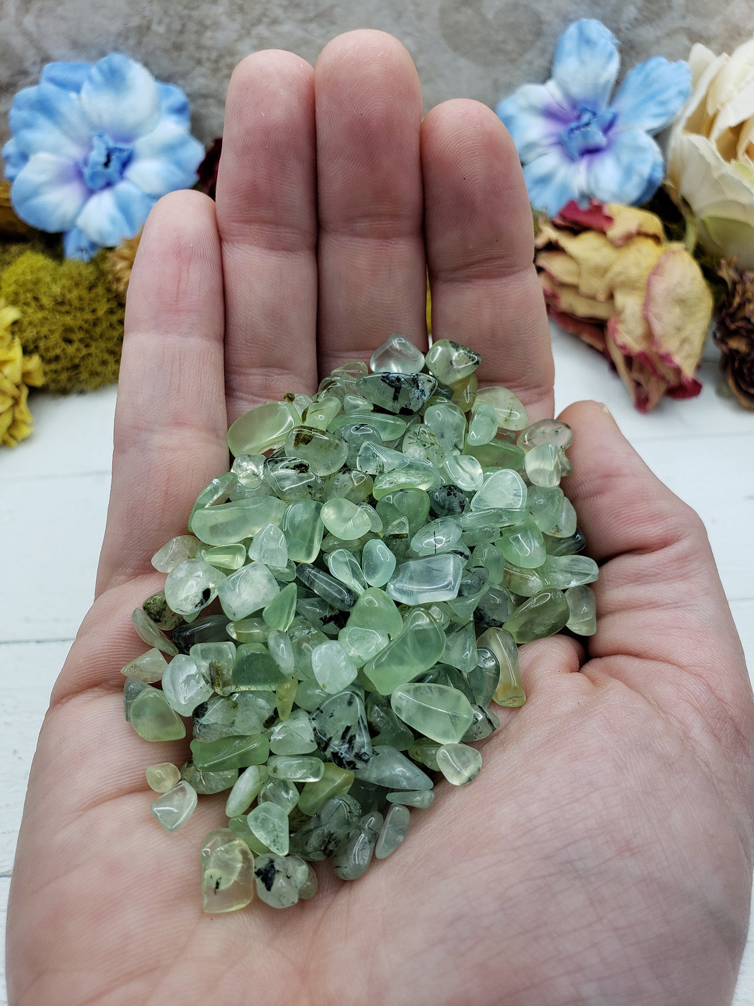 Three ounces of prehnite stone chips in hand