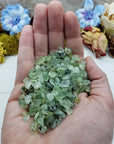 Three ounces of prehnite stone chips in hand