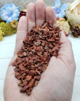 hand holding three ounces of red jasper stone chips