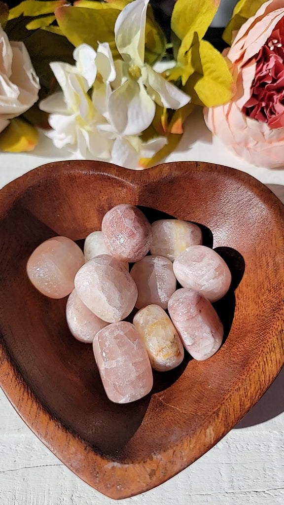 video of tumbled rose calcite stone held in hand