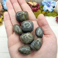 Camouflage jasper stone pieces in hand