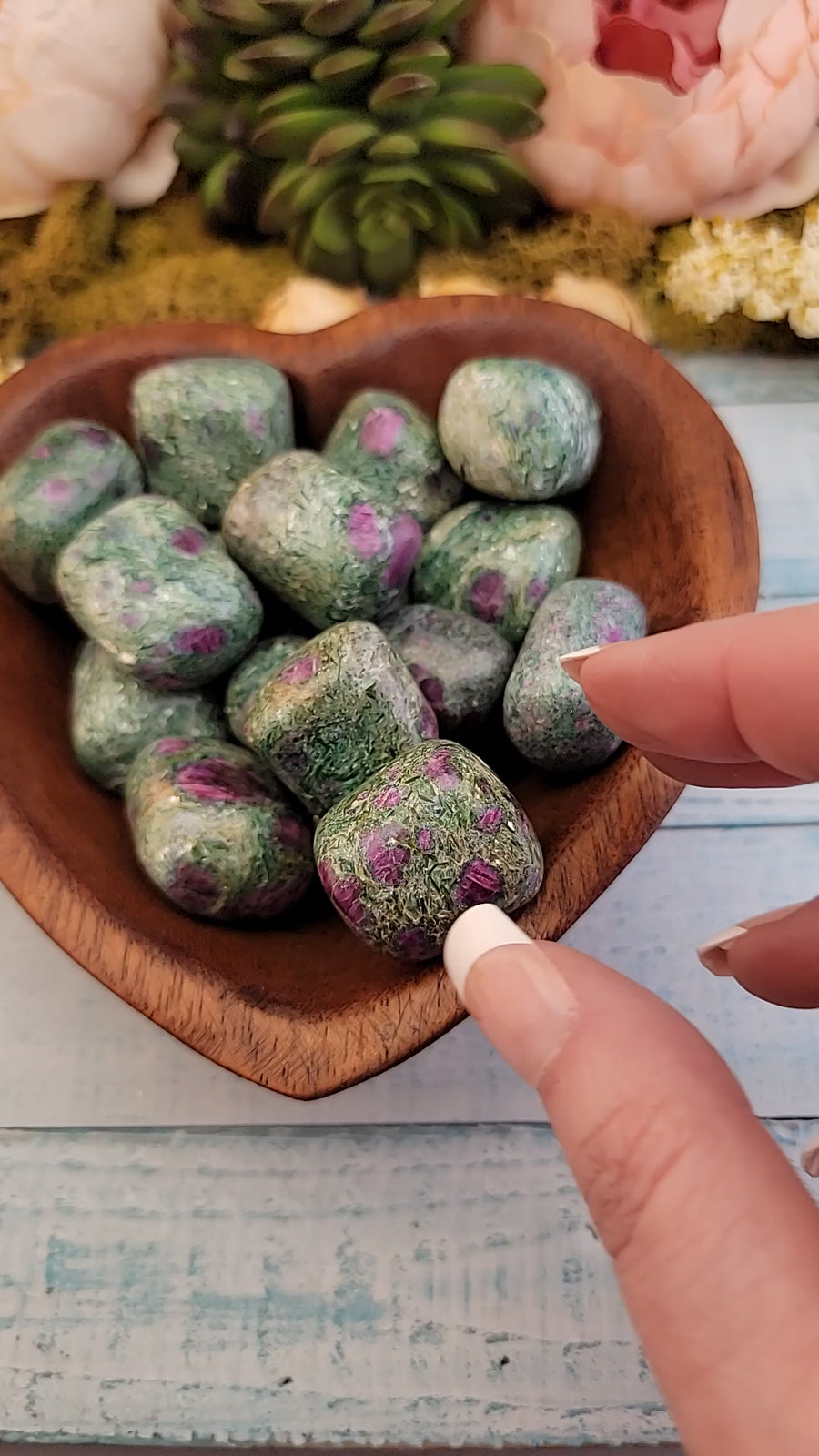 video of hand showing off multiple tumbled ruby kyanite fuchsite stones