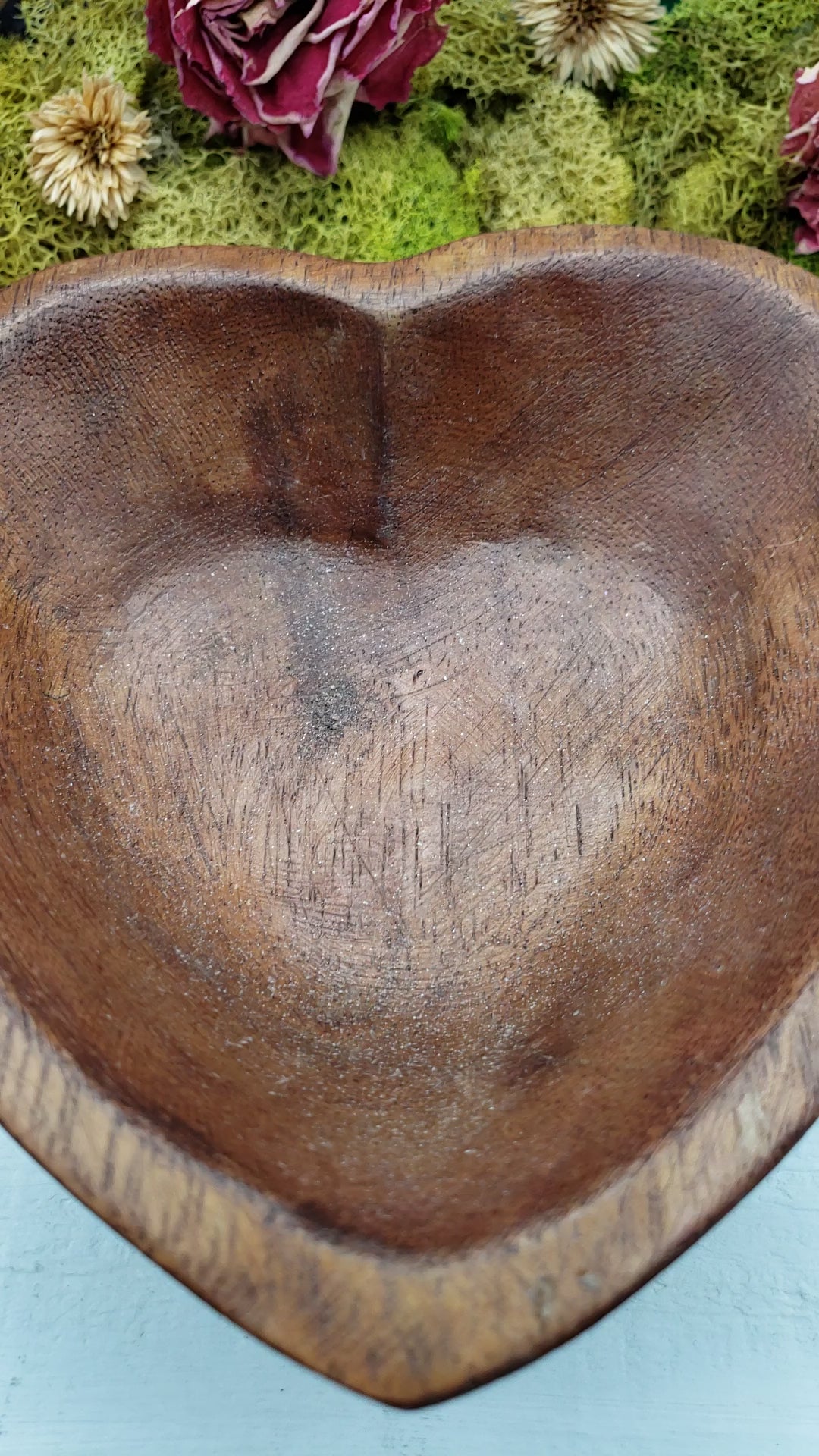 Video of amethyst crystal chips being poured into a heart-shaped bowl