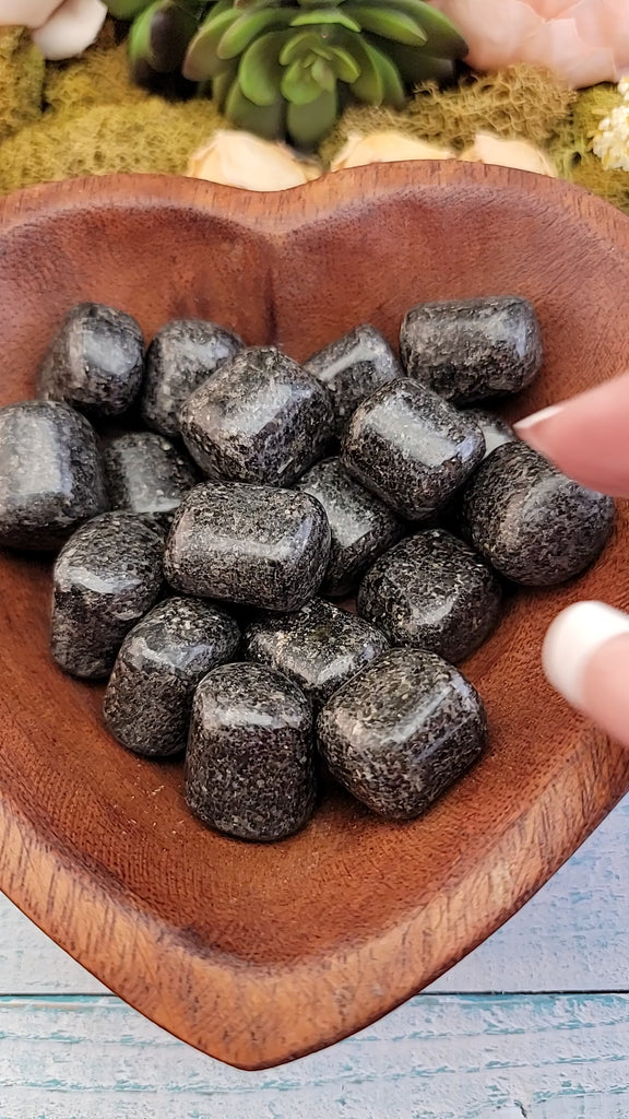 video of tumbled green nuummite coppernite stones in hand