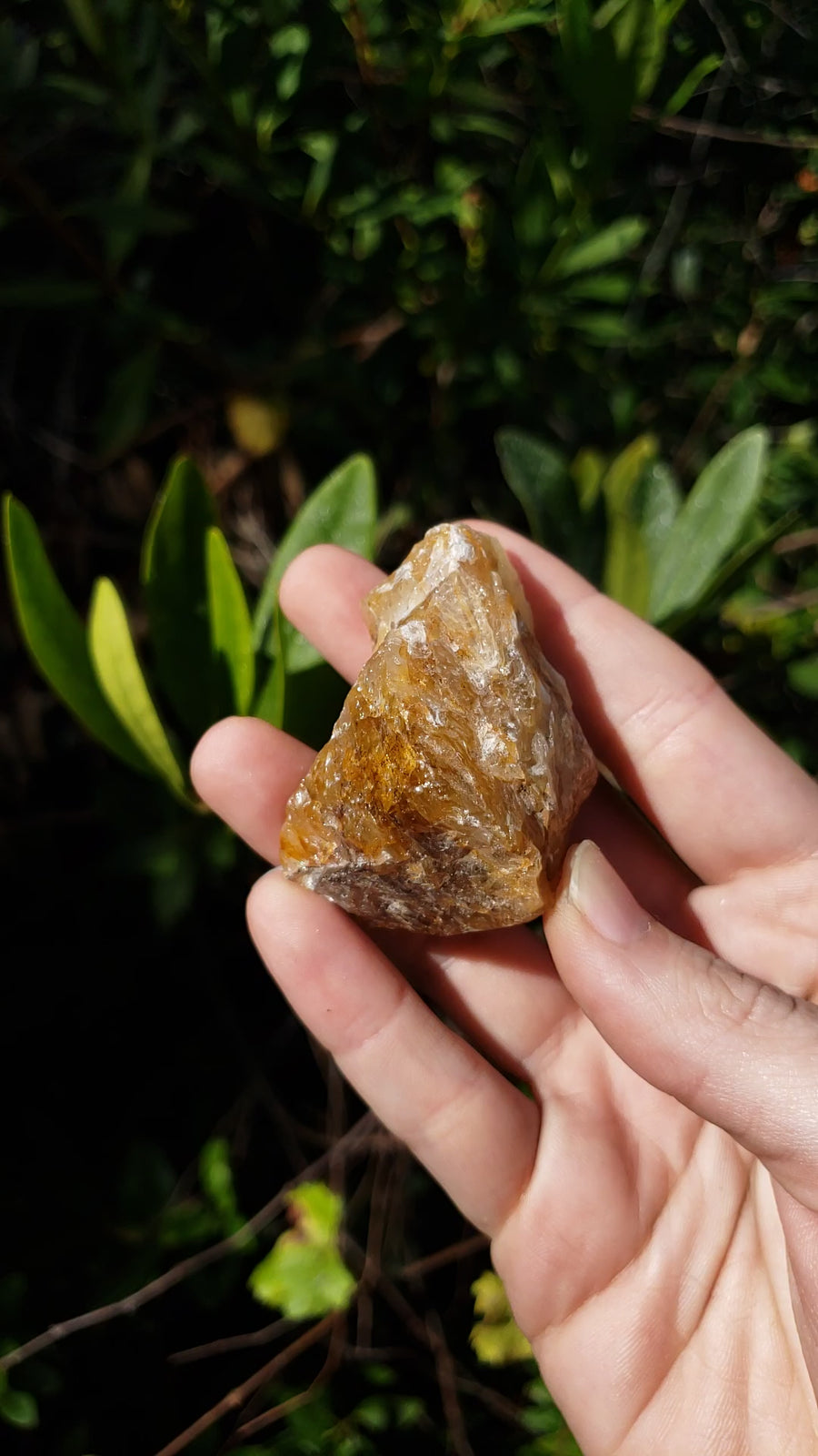 video of someone showing off rough fire quartz in sunlight