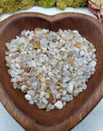 eight ounces of cherry blossom agate chips in wooden bowl