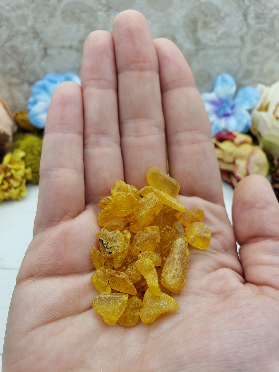 hand holding 9 grams of amber stone chips