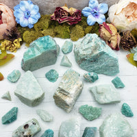 Rough amazonite crystal stones on display, spread out showing various sizes