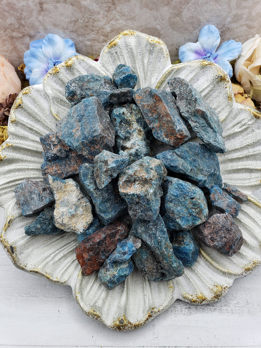 Collection of rough blue apatite stones on floral display dish