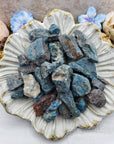 Collection of rough blue apatite stones on floral display dish