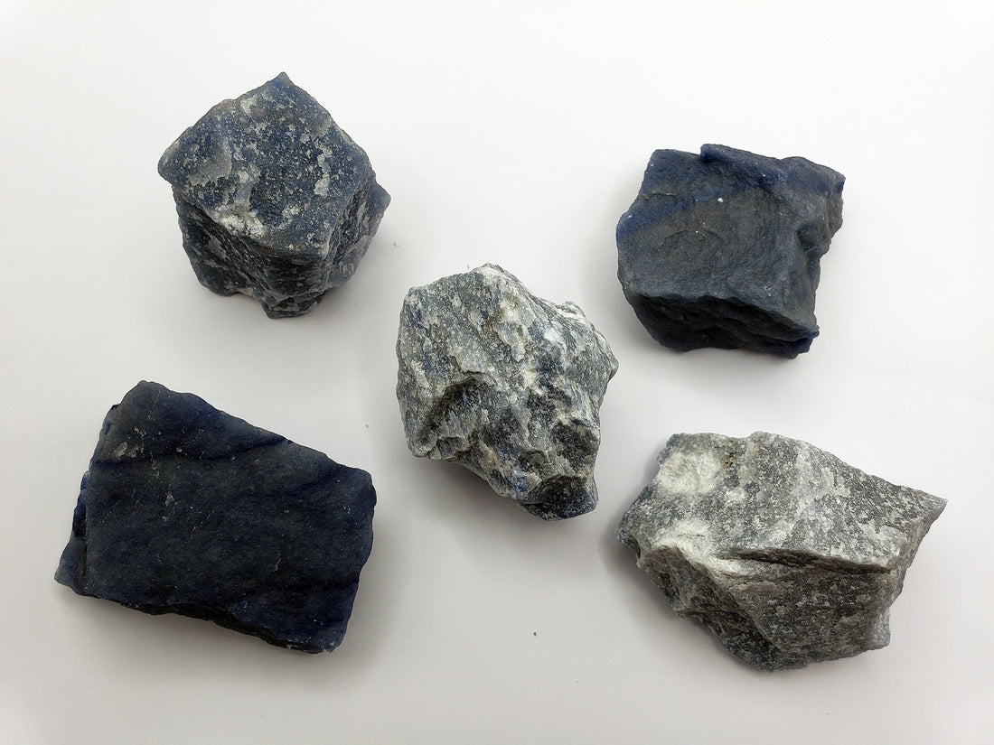 multiple rough blue quartz crystal chunks on white background