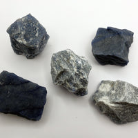 multiple rough blue quartz crystal chunks on white background
