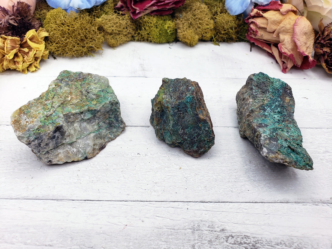 three rough chrysoprase crystal stones on display