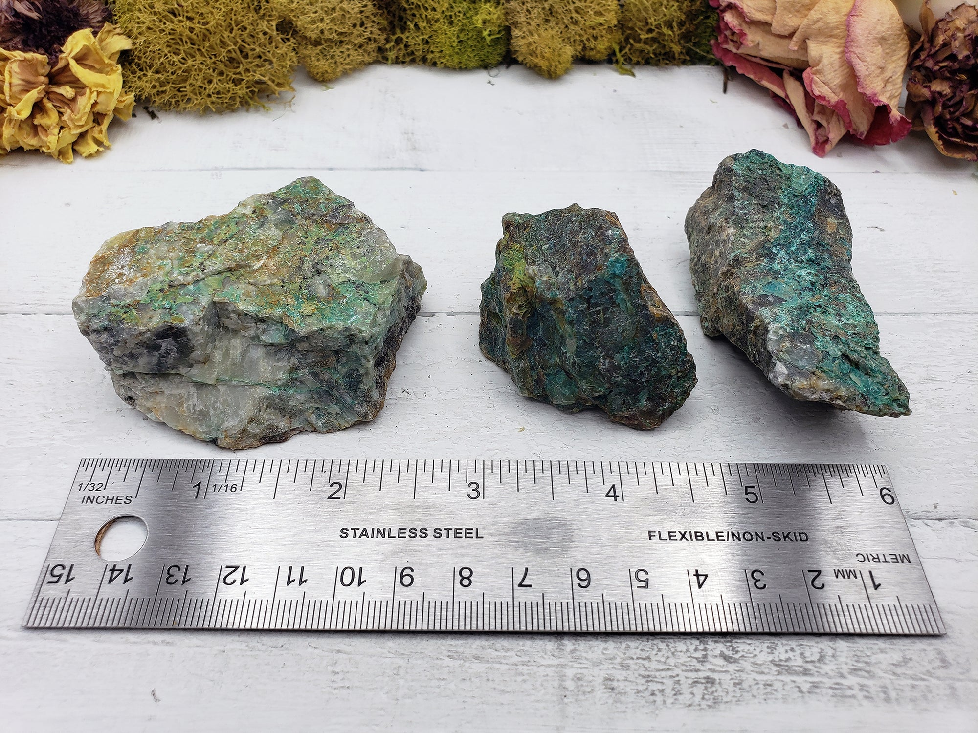 ruler comparing size of three rough chrysoprase stones