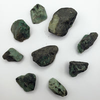 rough emerald stone pieces on white background