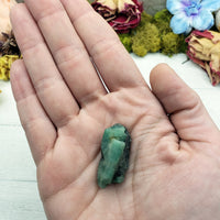 hand holding rough emerald stone