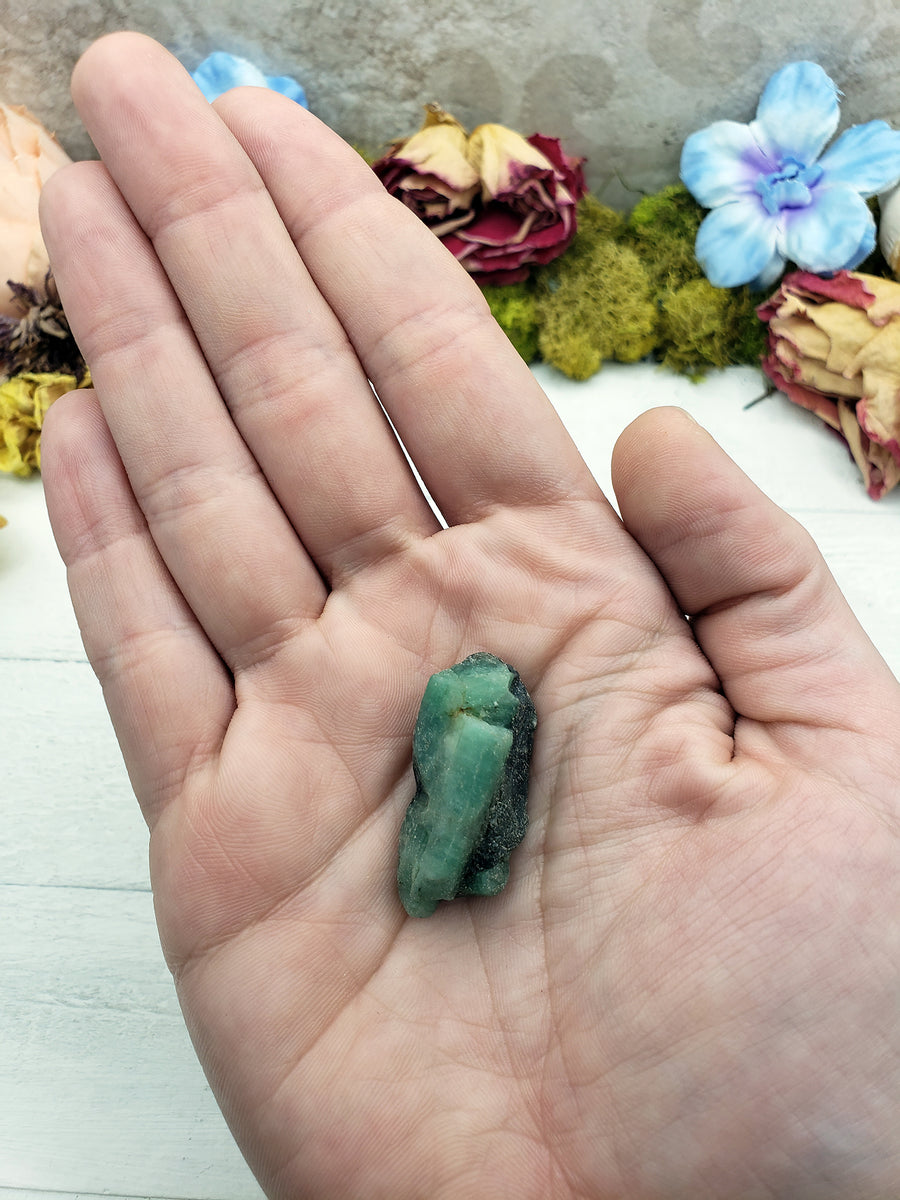 hand holding rough emerald stone