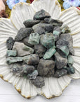 floral dish display with rough emerald stone pieces