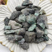 floral dish display with rough emerald stone pieces