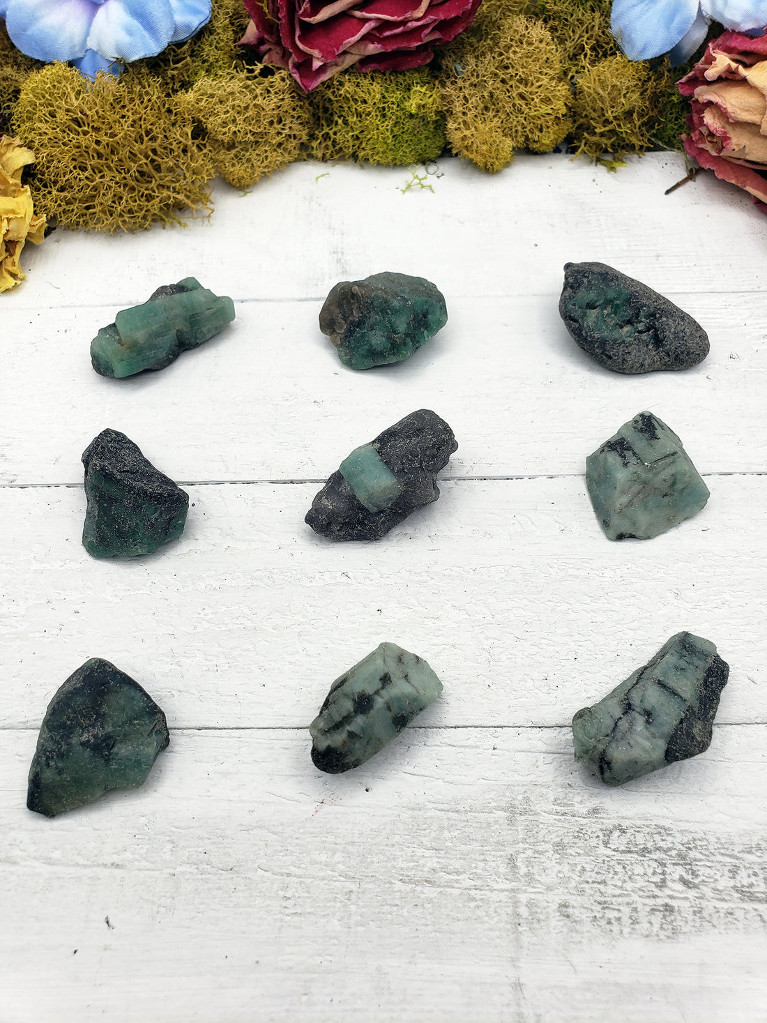 nine rough emerald stones on display