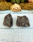 two rough epidote crystal pieces on display