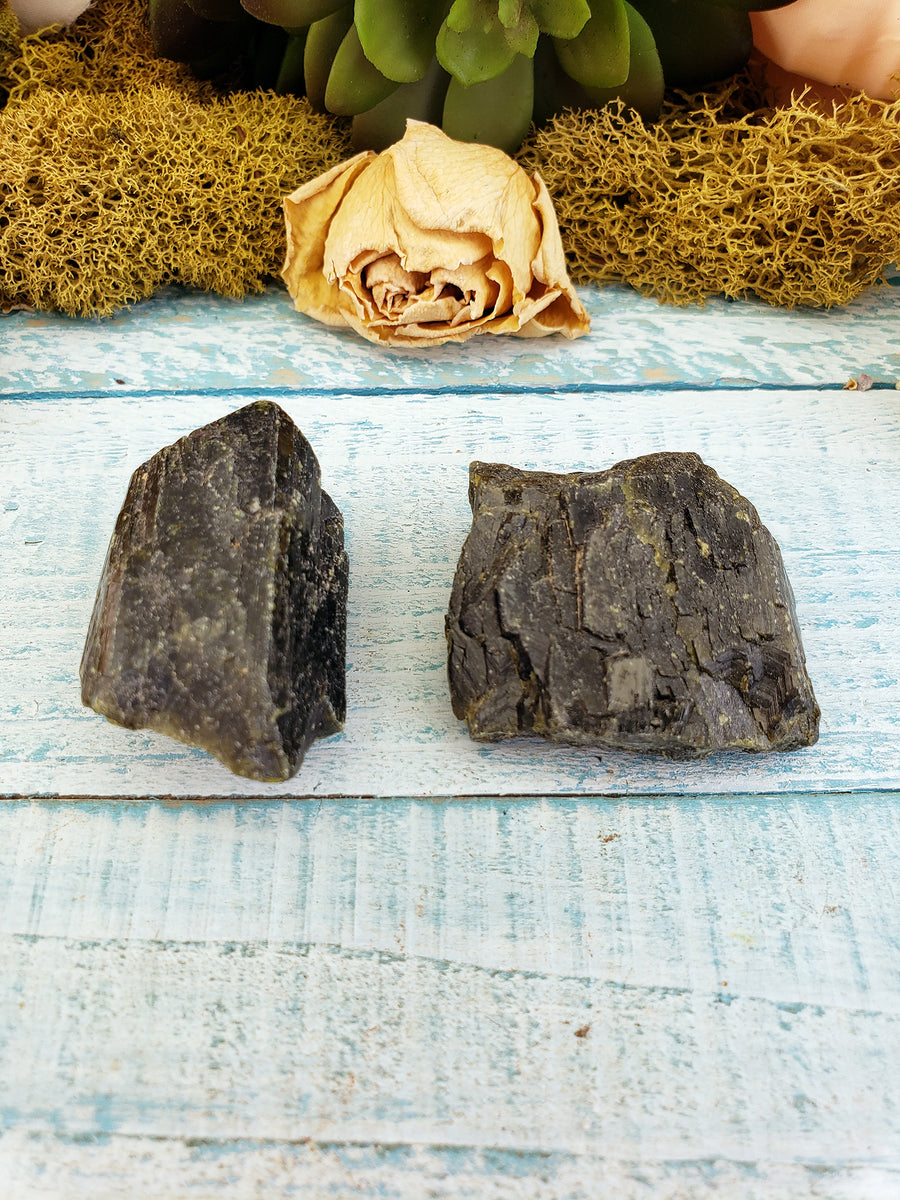 two rough epidote crystal pieces on display