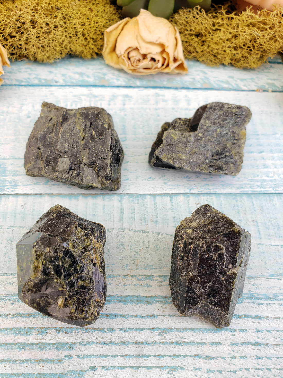 four rough epidote stone pieces on display